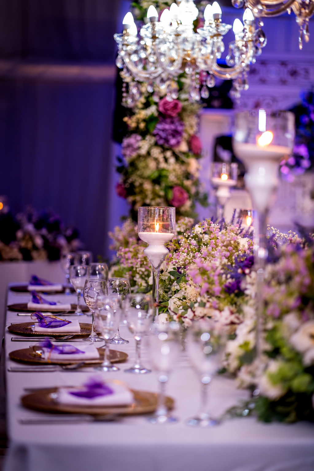 Wedding table with flowers, candles and purple lighting