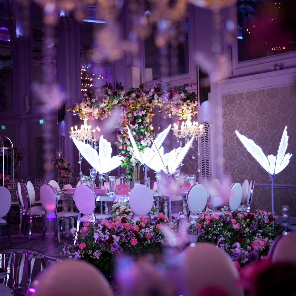 Illuminated butterflies among floral table arrangements