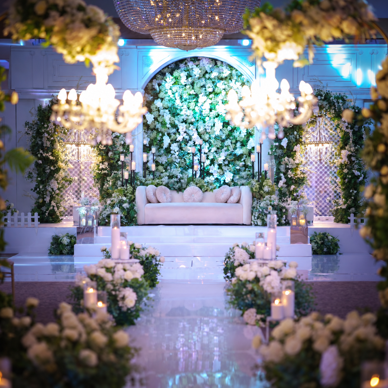White floral backdrop and candlelit aisle