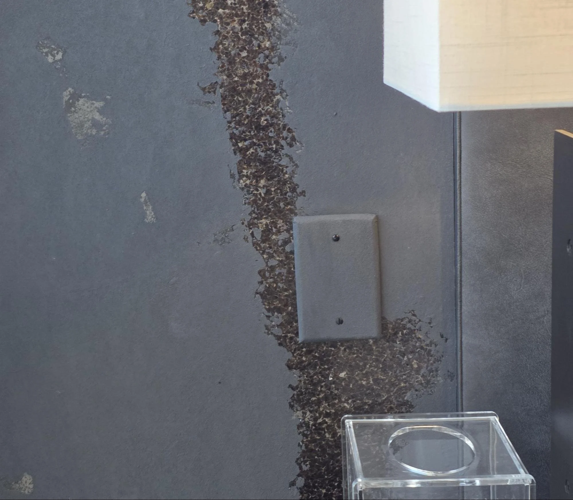 Close view of a cover plate wrapped in matching wallcovering.