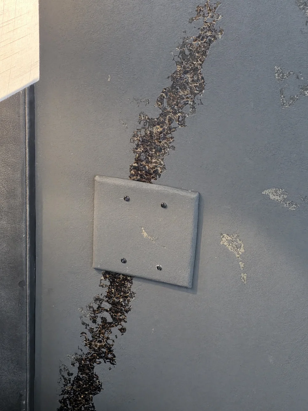 Electrical cover plate wrapped in Phillip Jeffries wallcovering in a Boulder bedroom.
