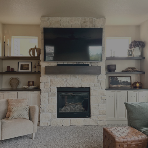 An entertainment system custom built for a client of ours. A tv and fireplace sits in the middle with our built in cabinets and shelving to the left and right.