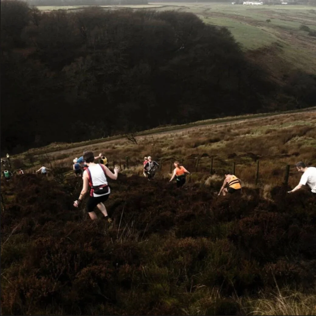 Fell runners crossing open moorland.
