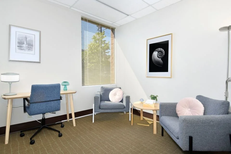 Paul Walsh's therapy office in Johns Landing, Portland, with two armchairs, a small desk and a framed lighthouse print