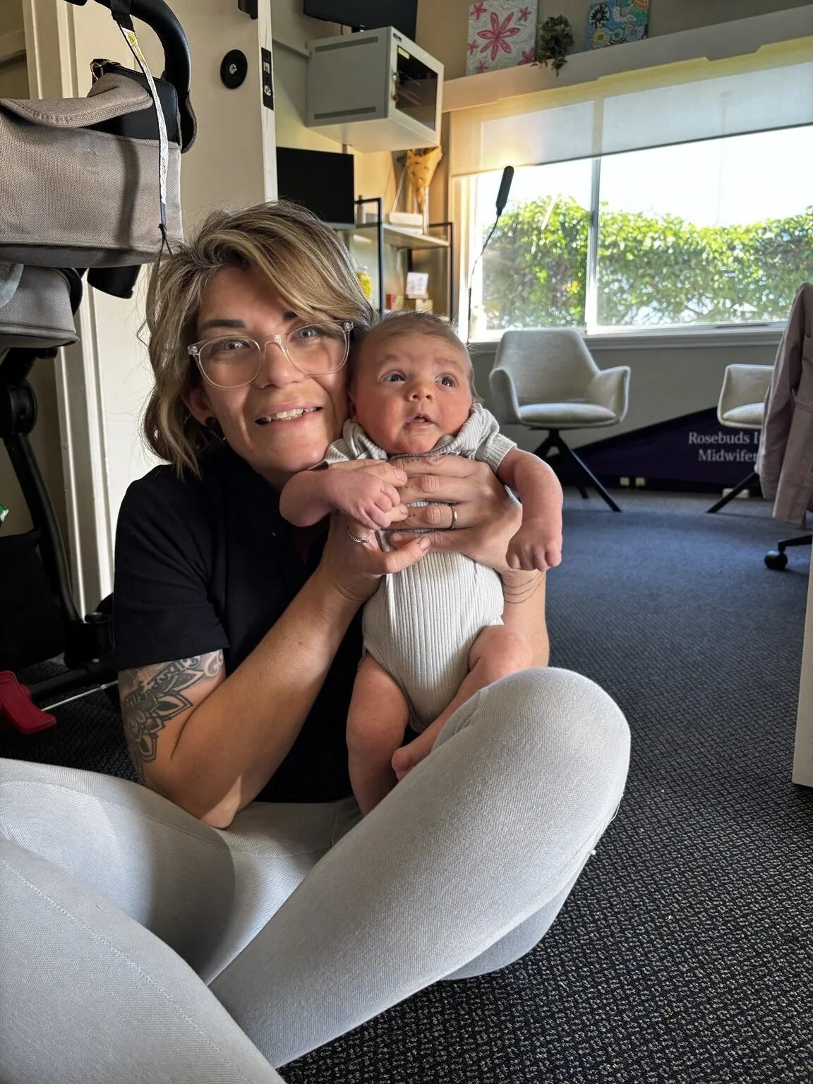 Emma holding a newborn baby in the Rosebuds clinic