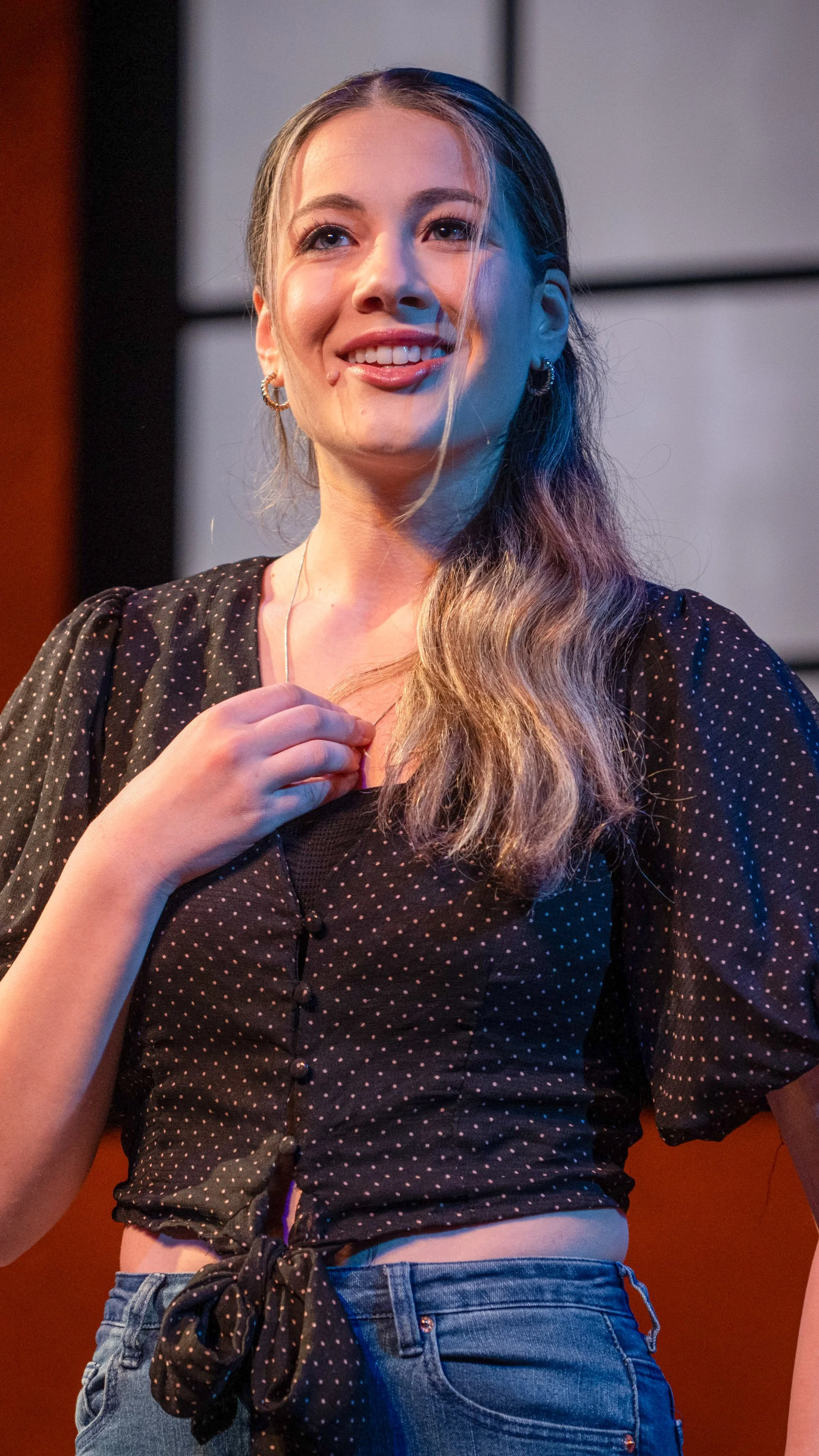 Performer sings into a headset microphone in Stoop Songs.