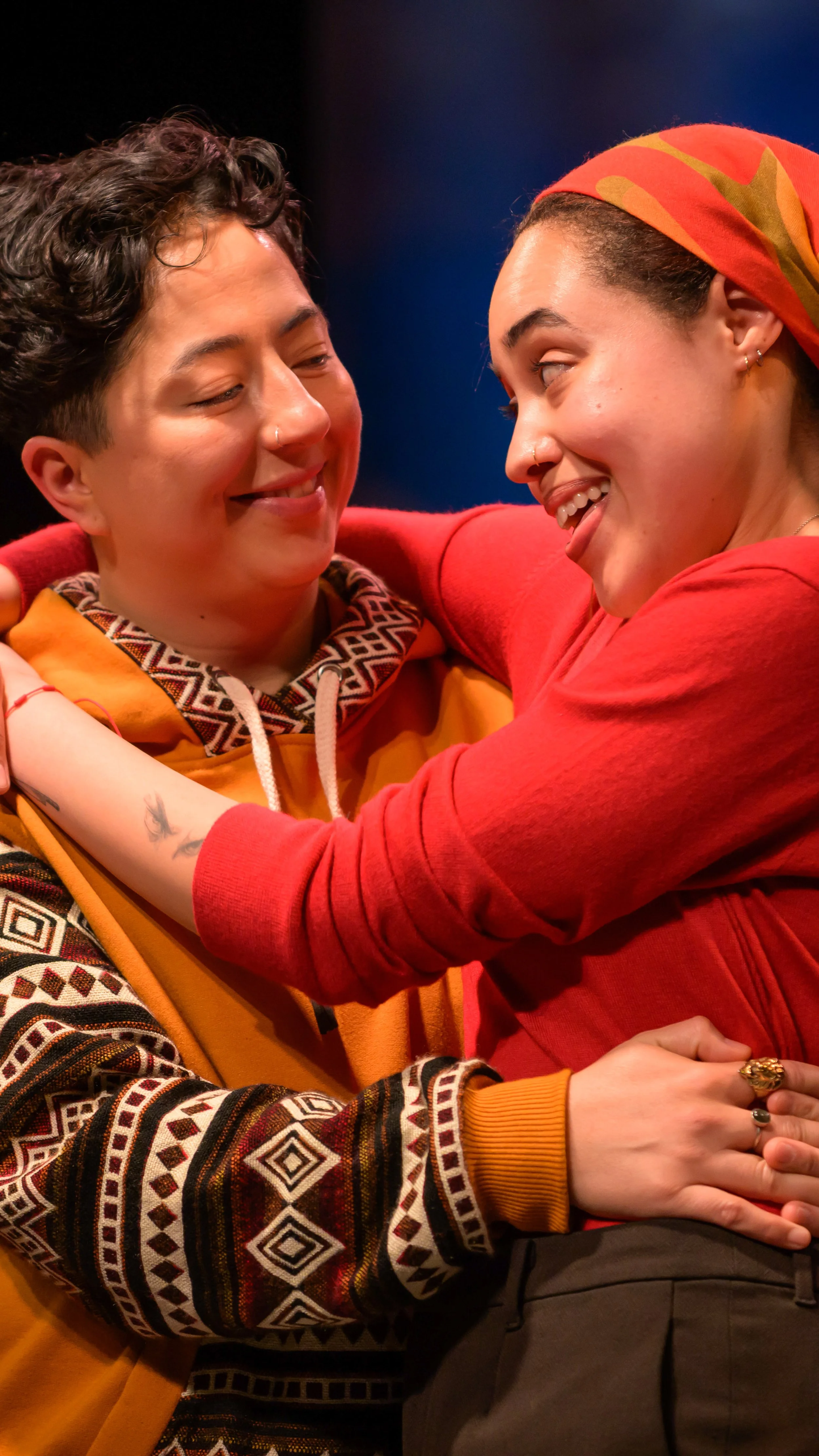 Two performers embrace under bright stage lights in The Waterfront.