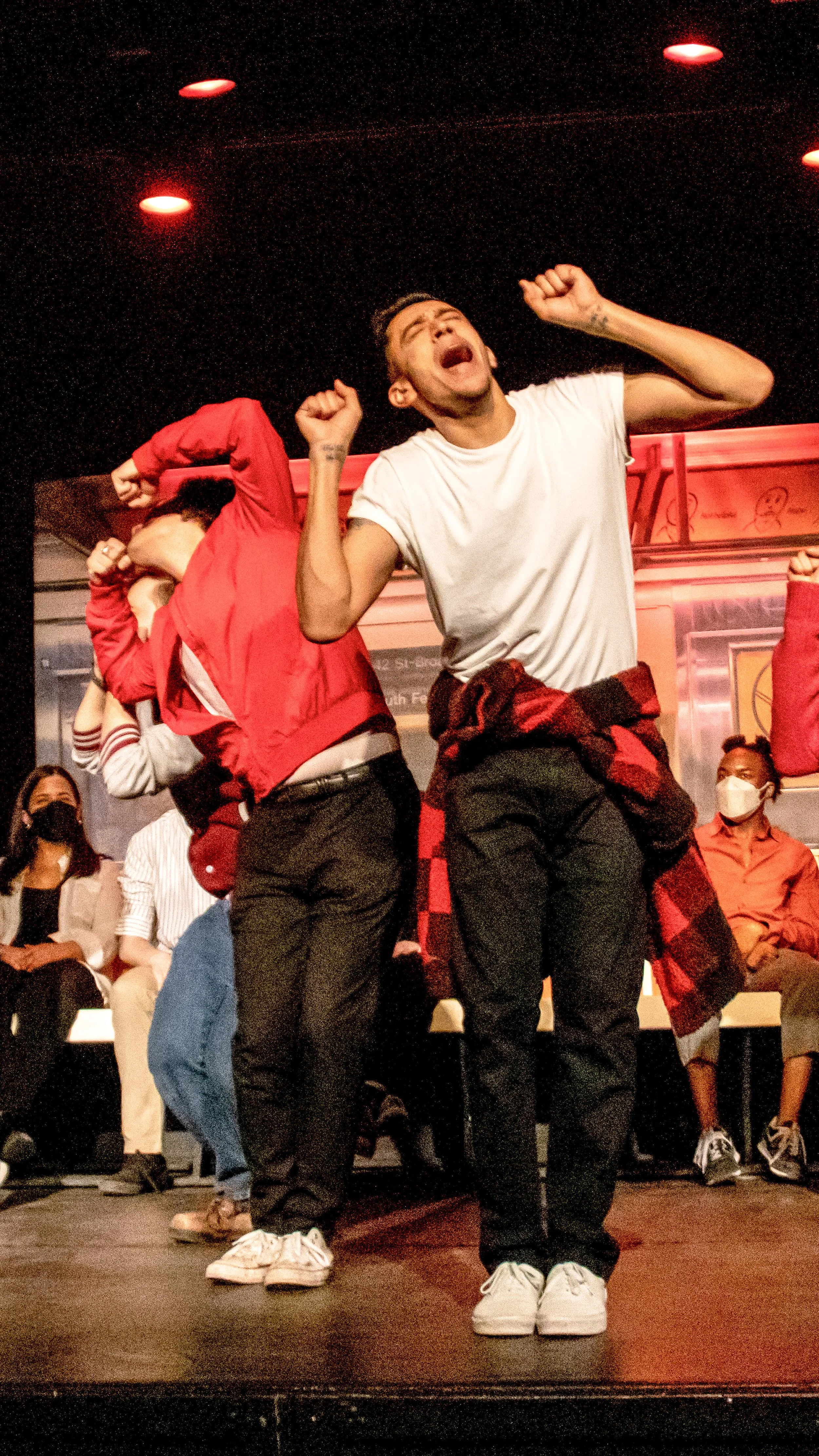 Dancers in red and white costumes perform an energetic number in Another Hundred People.