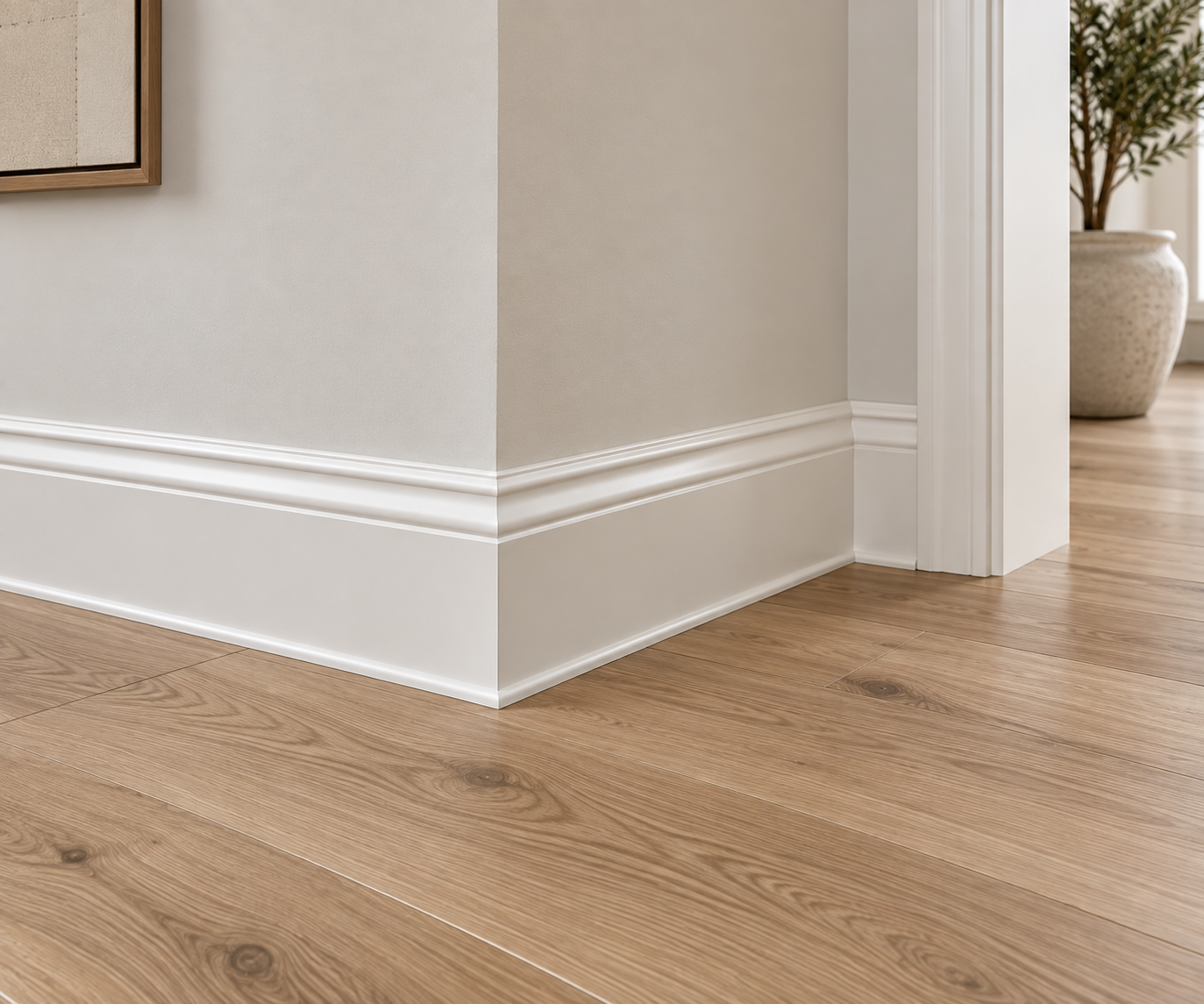 Baseboard and trim finish detail meeting wide-plank wood flooring