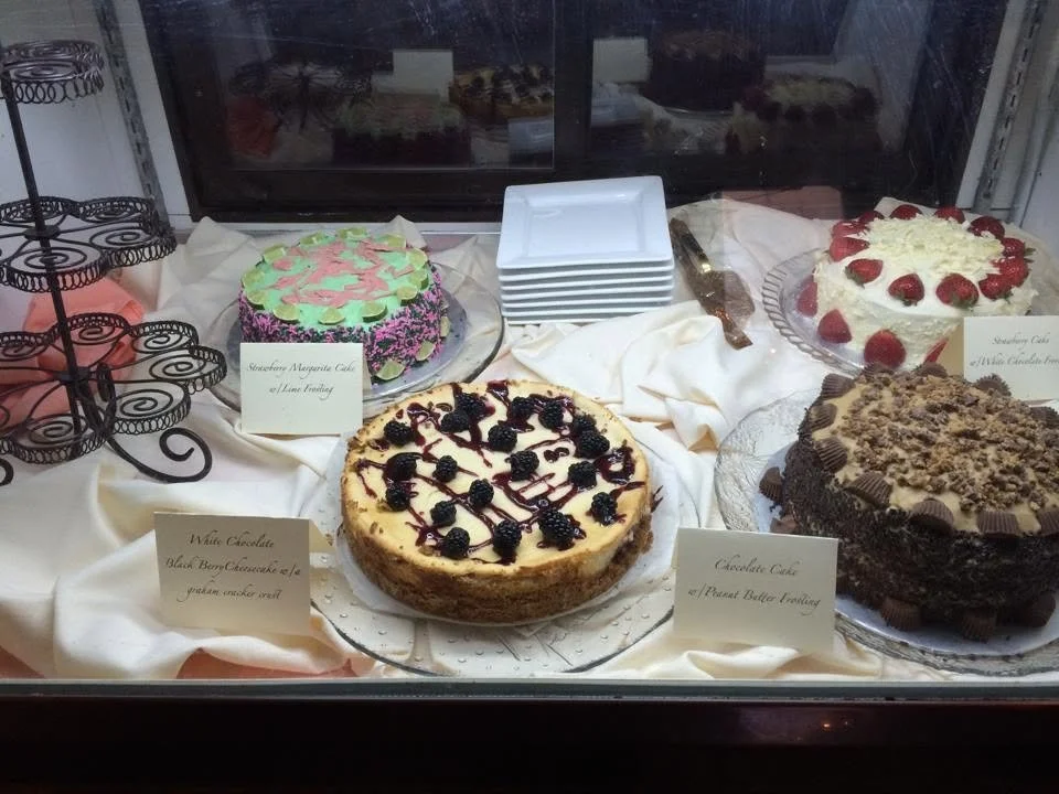 Assorted decorated cakes displayed with dessert cards at Ka-bobs.