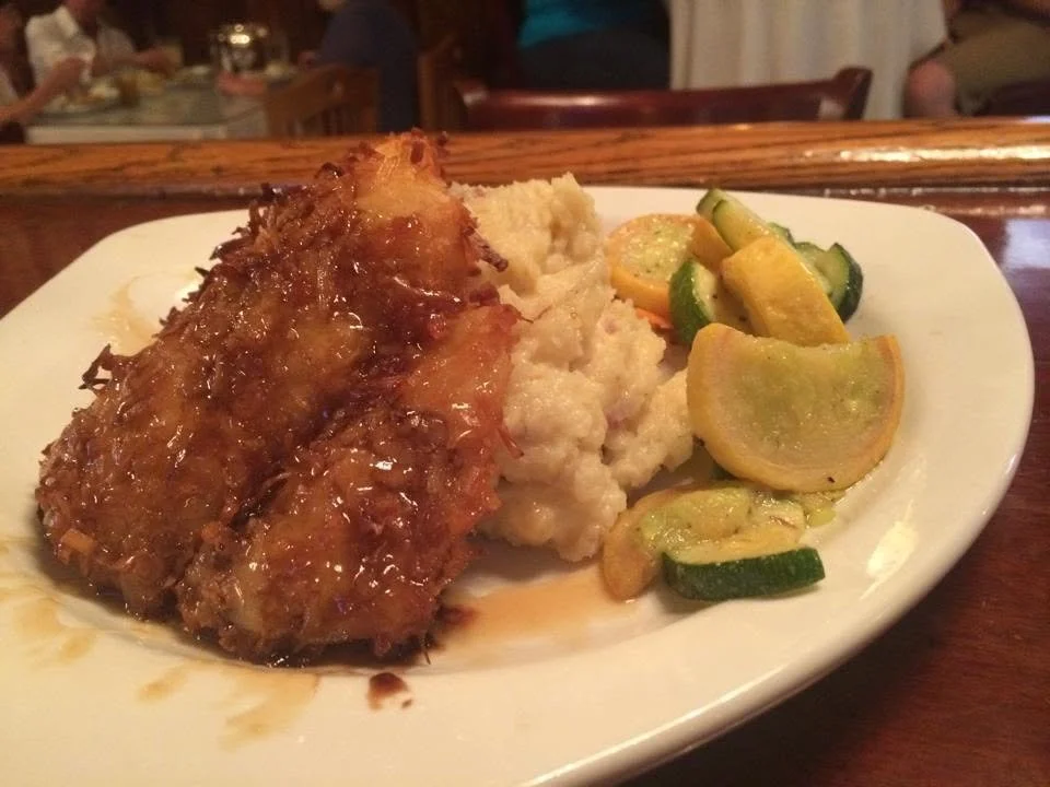 Browned entree served with mashed potatoes, mixed vegetables and a lemon wedge.