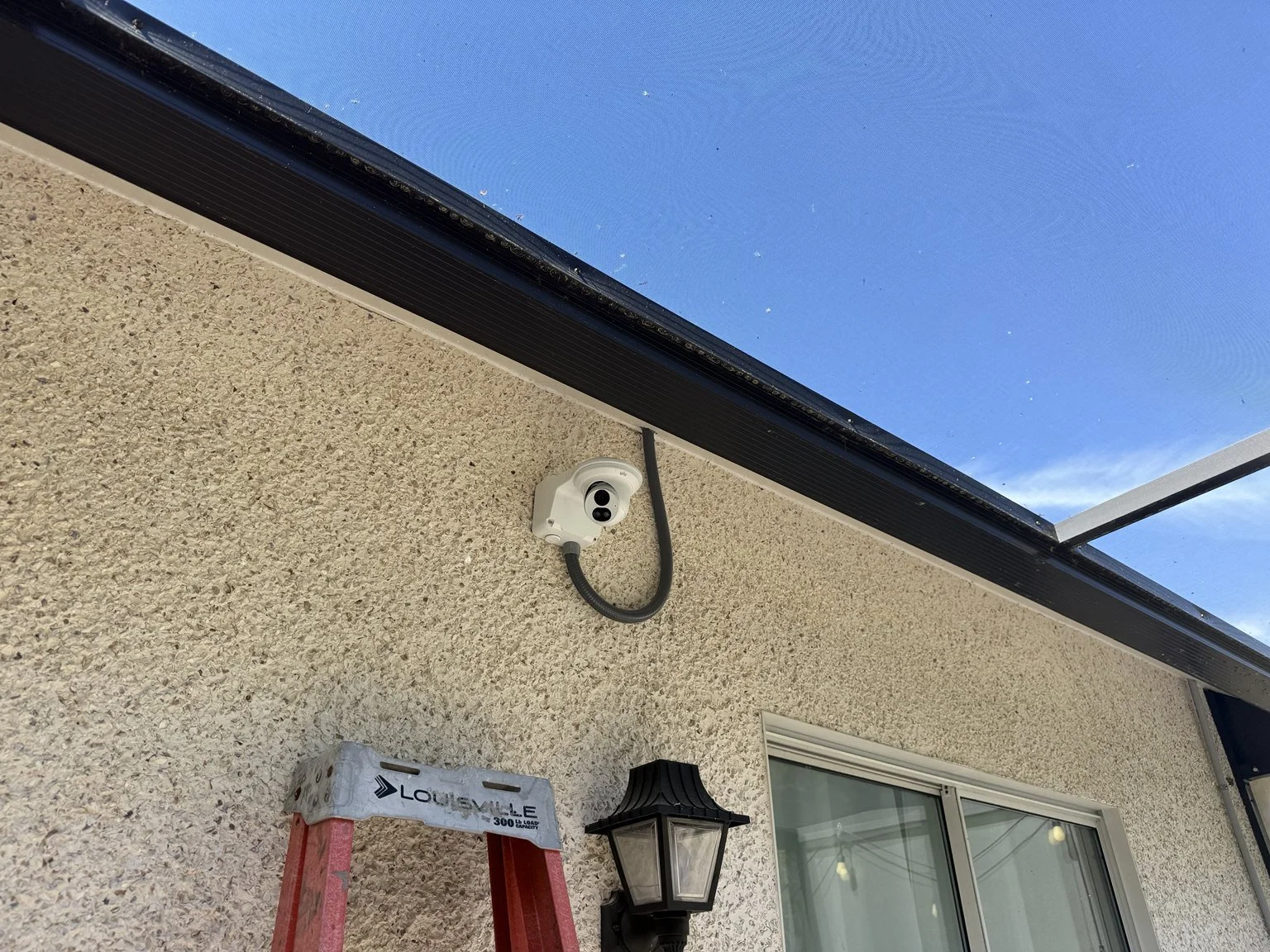 Exterior PoE security camera mounted beneath a residential roofline