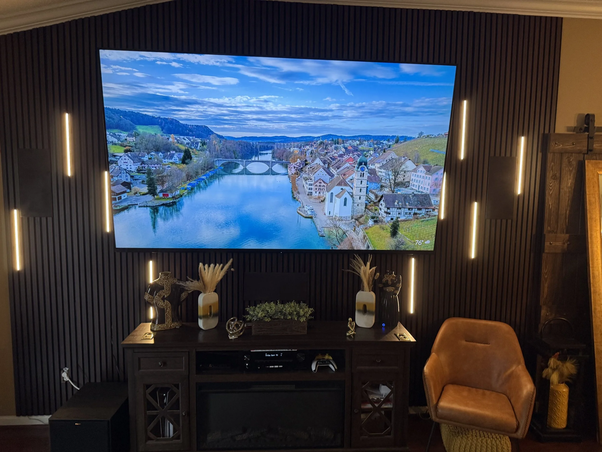 Finished custom media wall with a large display and warm illuminated accents