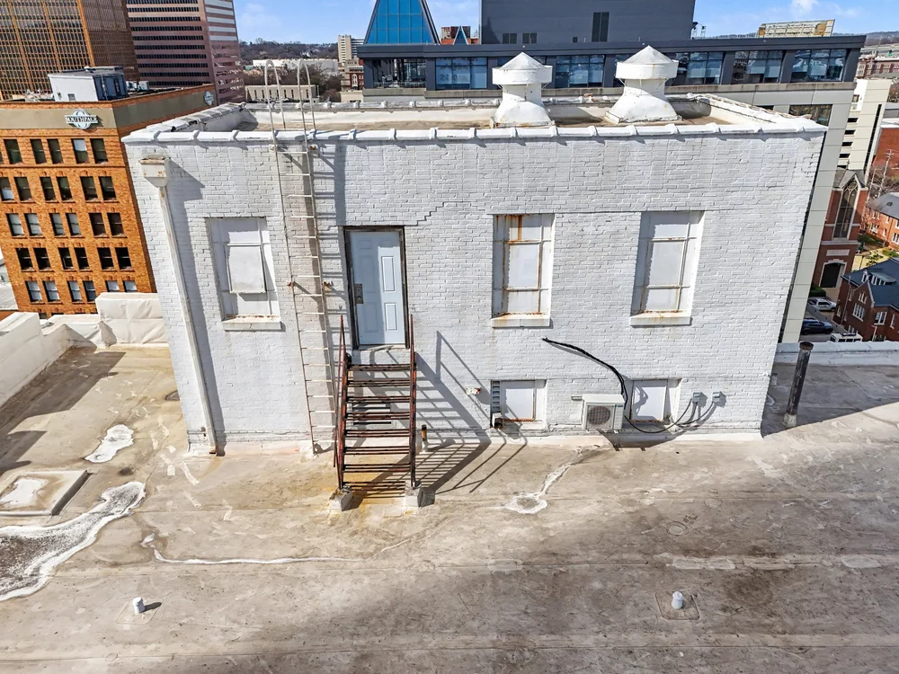 Rooftop penthouse: corroded frames and access stair