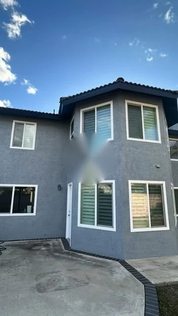 Before and after exterior painting of a two-story gray stucco home in Placentia, CA