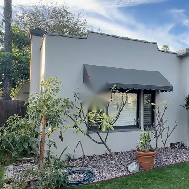 100-year-old Fullerton, CA home painted gray with dark awnings