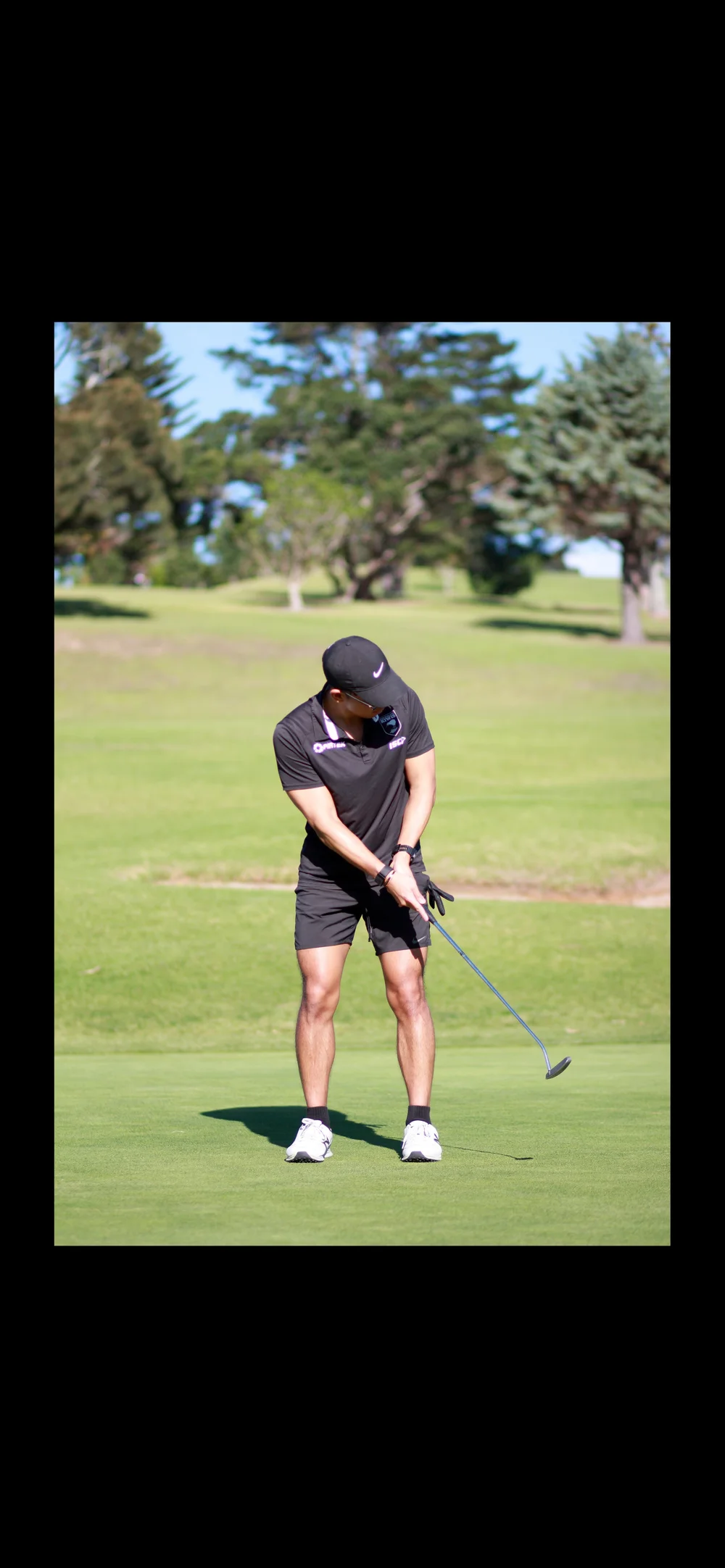Golfer mid-swing on the fairway