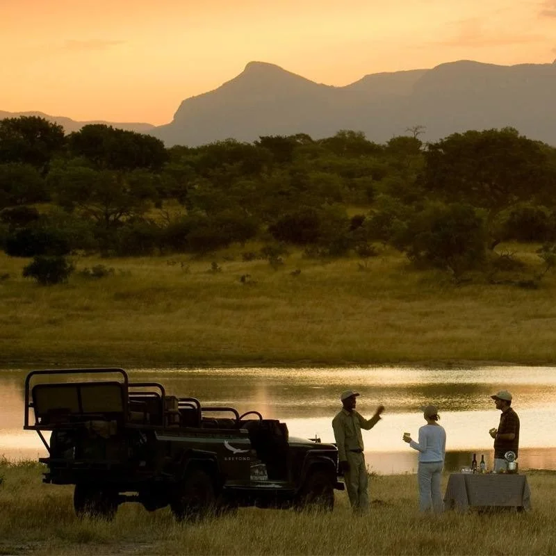 Sundowners beside an &Beyond vehicle