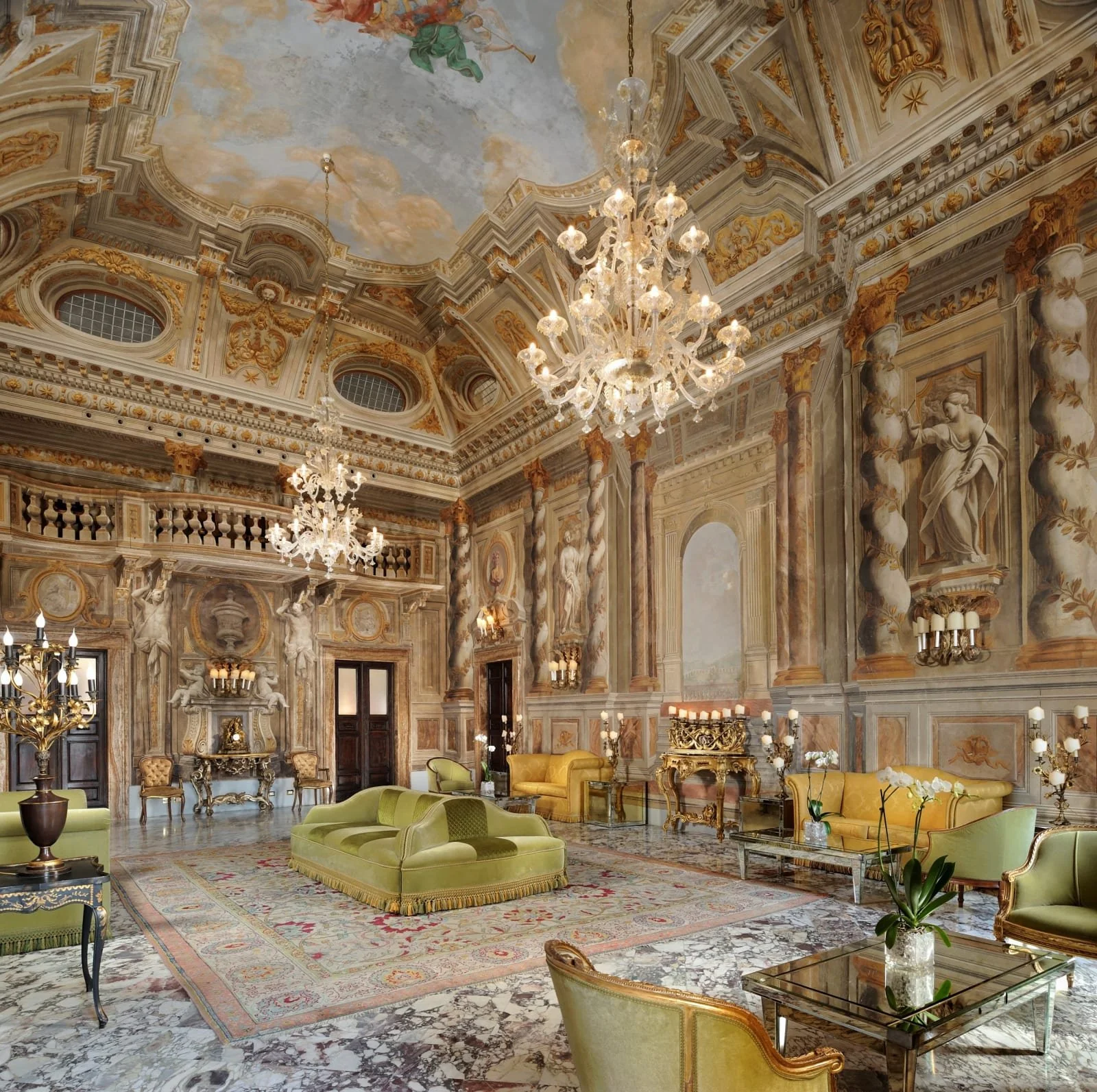 Frescoed salon with chandeliers at Grand Hotel Continental Siena