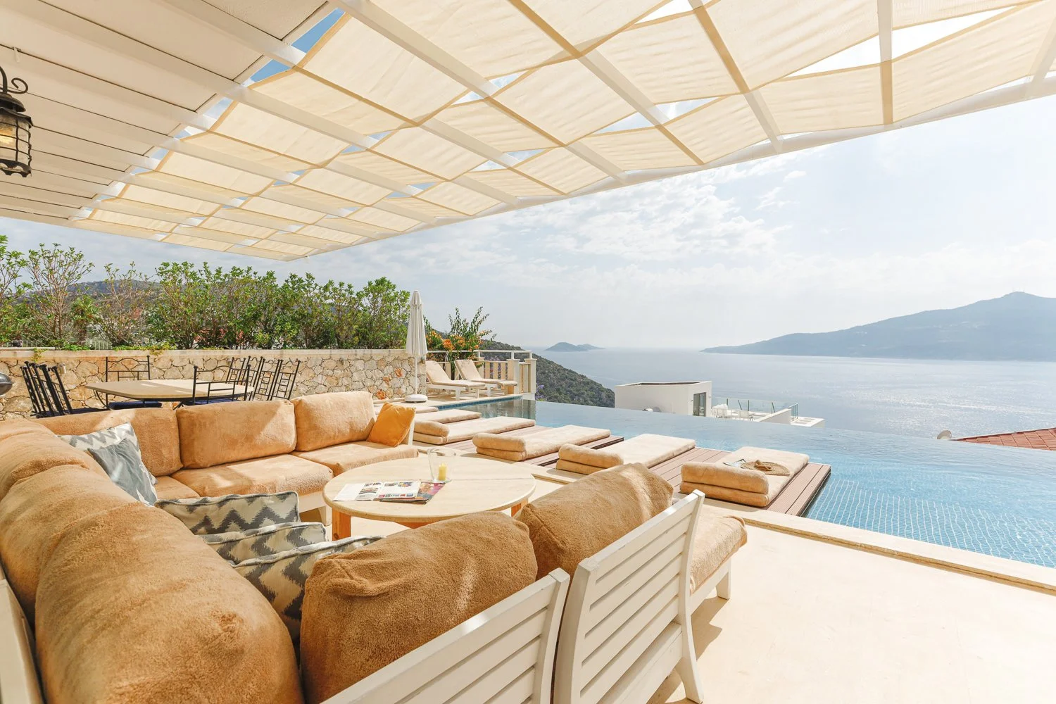 Hotel terrace with lounge seating and an infinity pool overlooking the sea