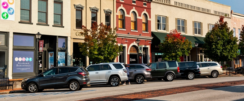 Historic downtown storefronts along a tree-lined street in Decatur, Alabama