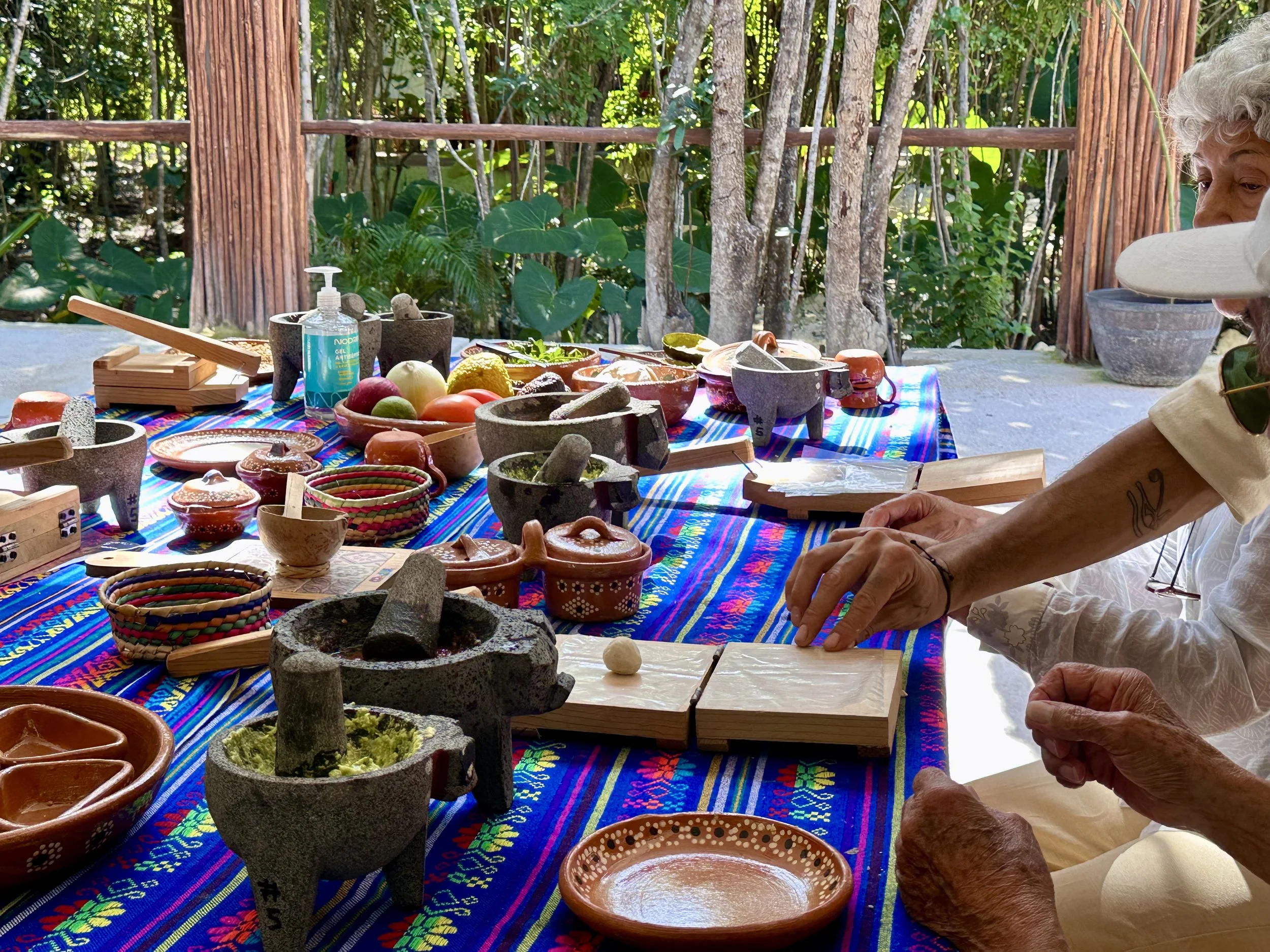 Grinding Mayan pumpkin-seed salsa in a volcanic stone molcajete
