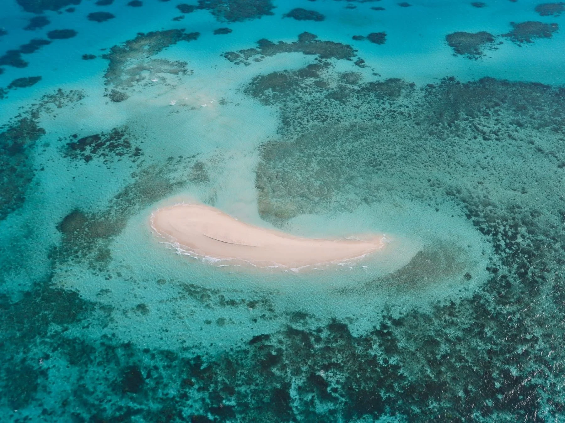 Aerial view of a sand cay ringed by turquoise reef on the Great Barrier Reef
