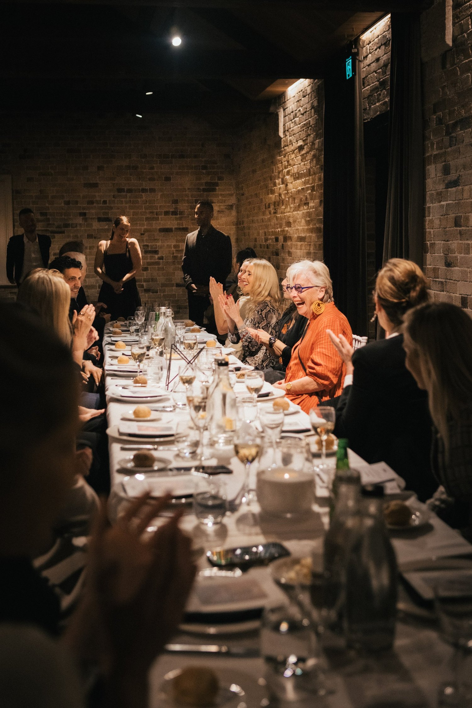 Guests seated along one long candlelit table at the VIP dinner
