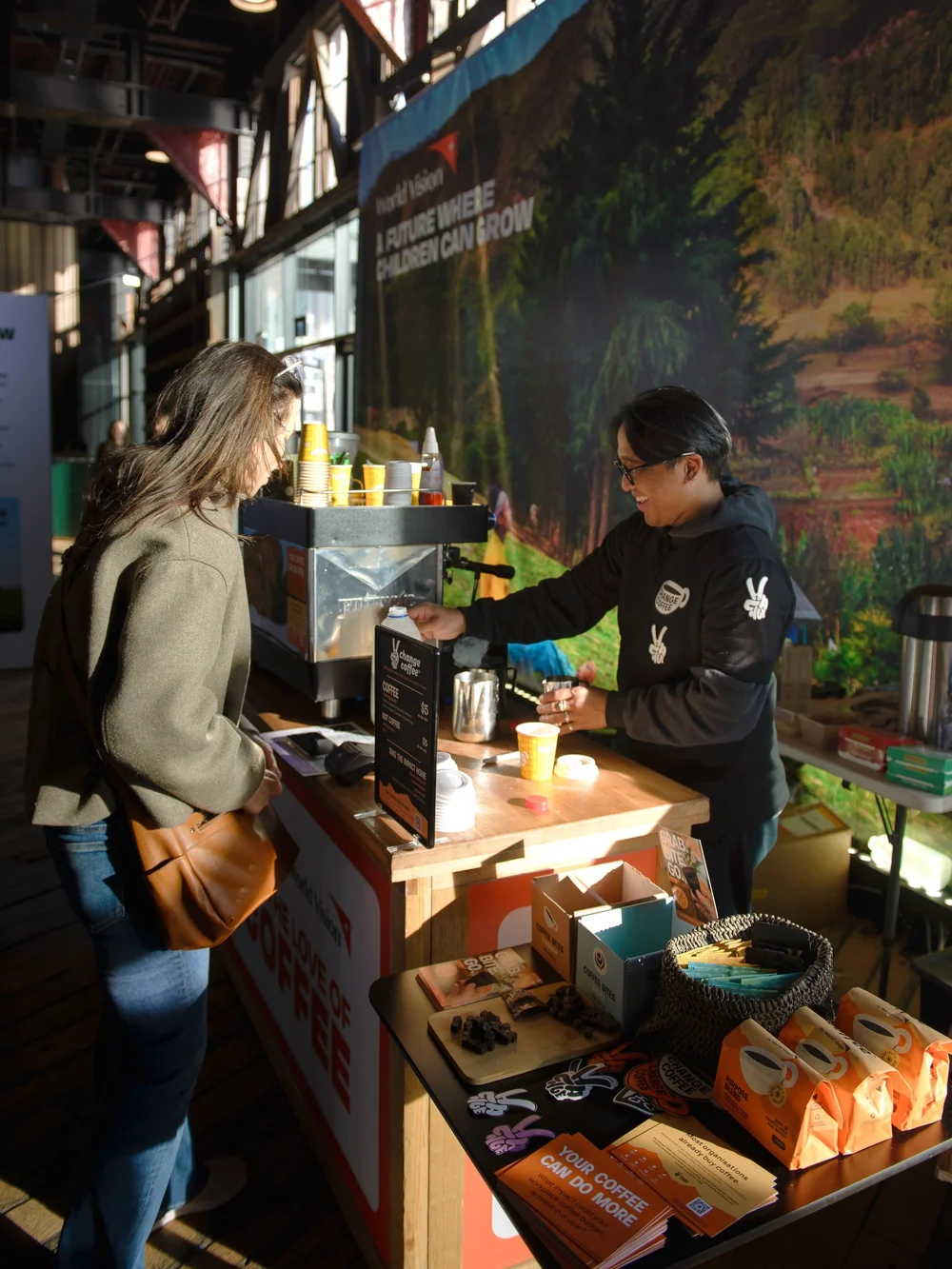 A barista at the Change Coffee cart