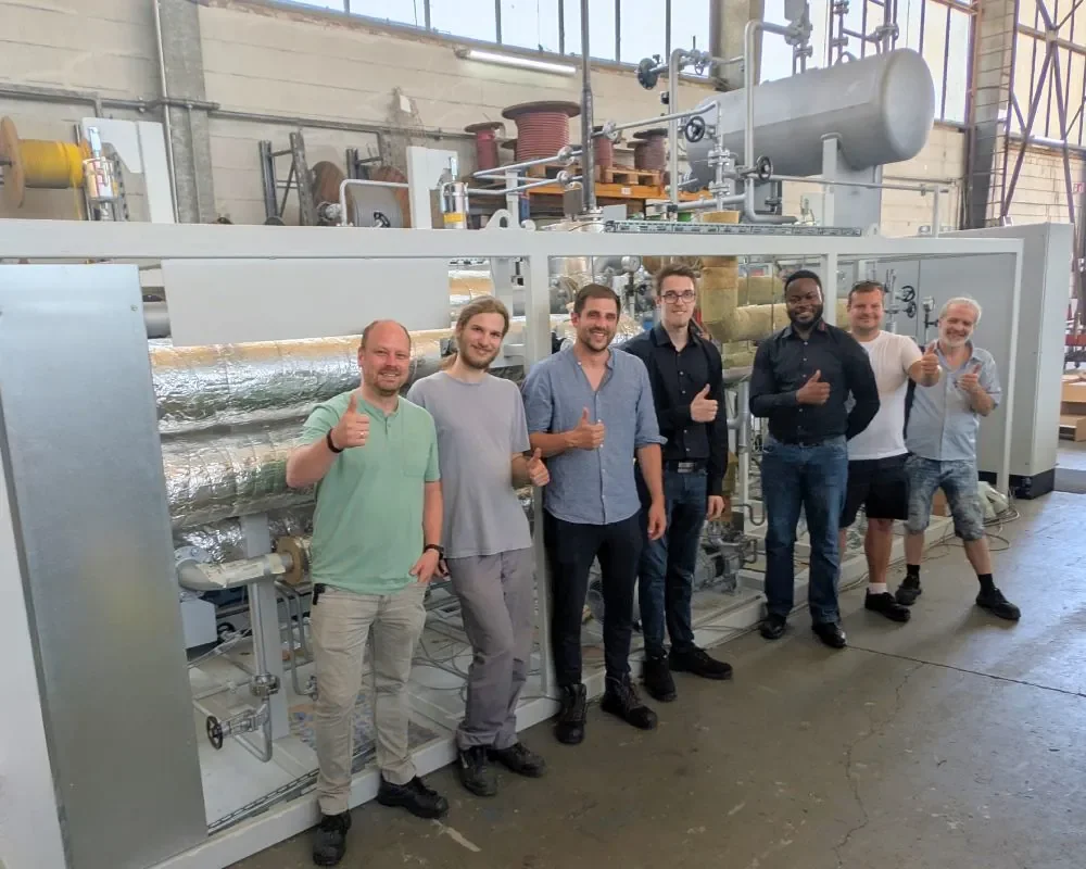 Projektteam vor dem Hochtemperatur-Pumpenprüfstand mit PROCESSTHERM S-460