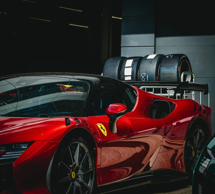 A red sports car beside a stack of tyres