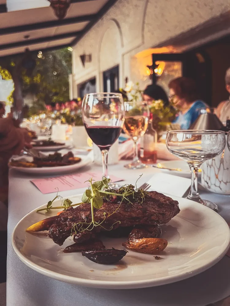 Steak dinner and wine glasses on the long table at the wedding reception