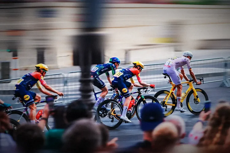 The peloton sweeping through Paris, riders sharp, city dragged into colour