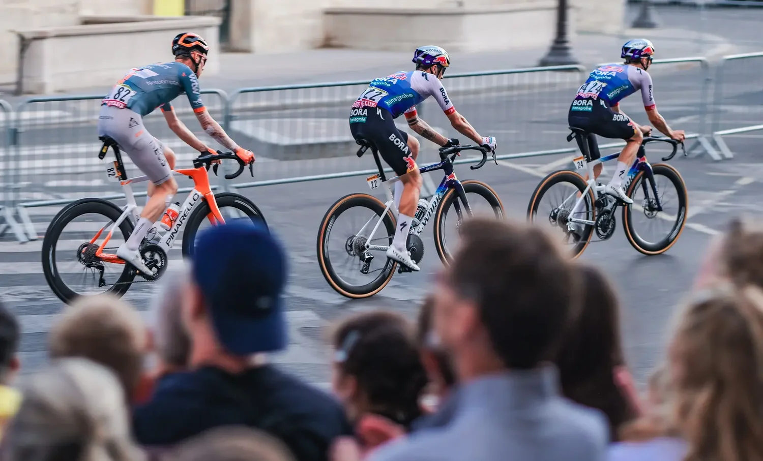 INEOS and Bora riders racing past the crowd on the final stage of the Tour de France 2026 in Paris