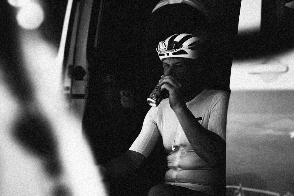 James sitting in the van door, exhausted, in grainy high-contrast black and white