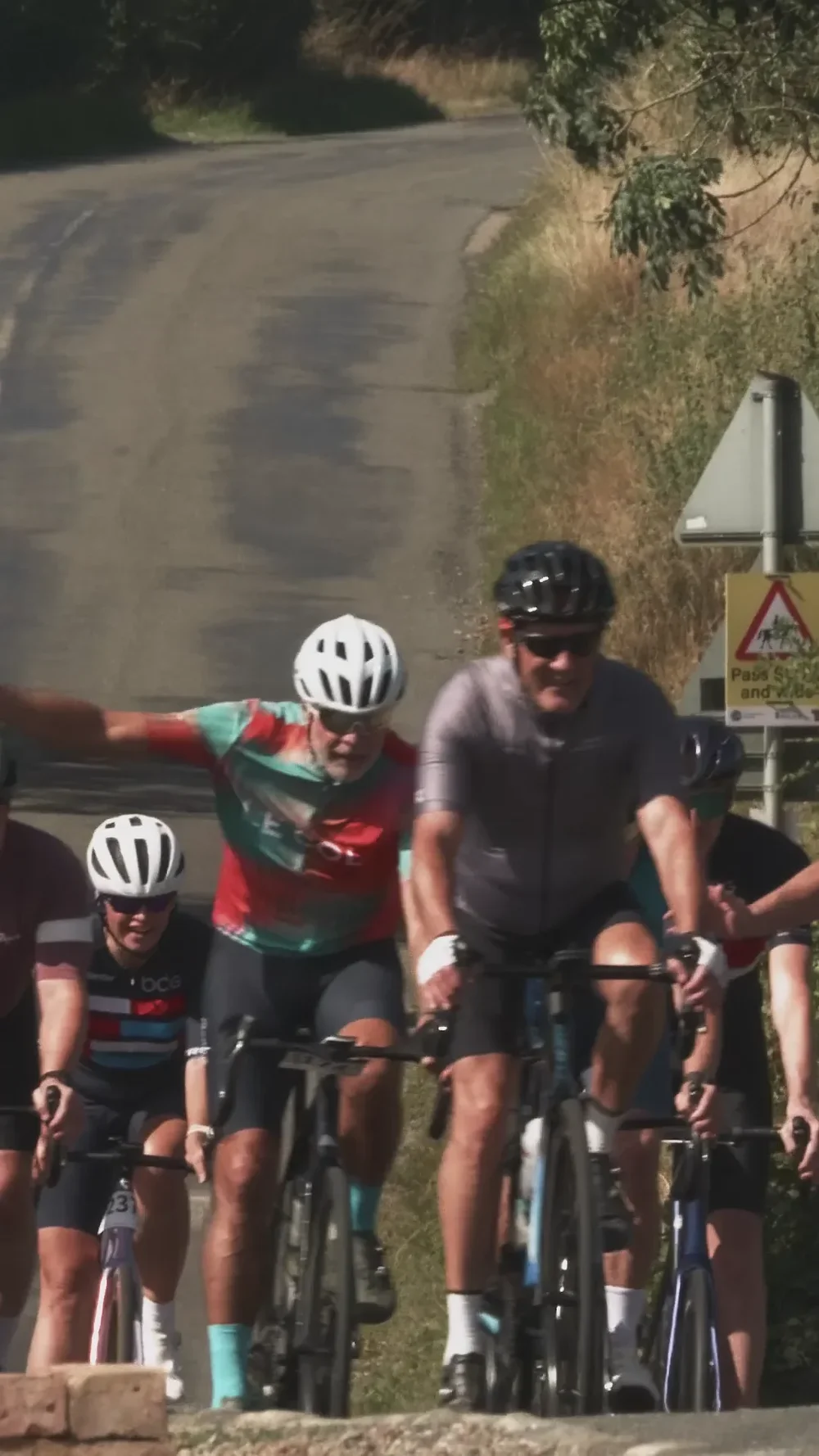 A group of riders climbing a country lane on a charity sportive