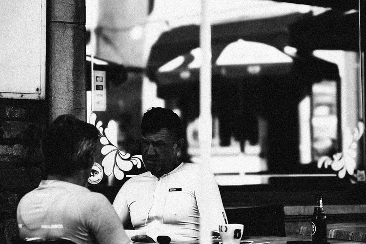 Two riders talking at a cafe table