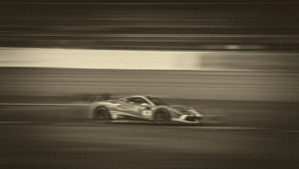 A black and white race car pulled into long horizontal streaks