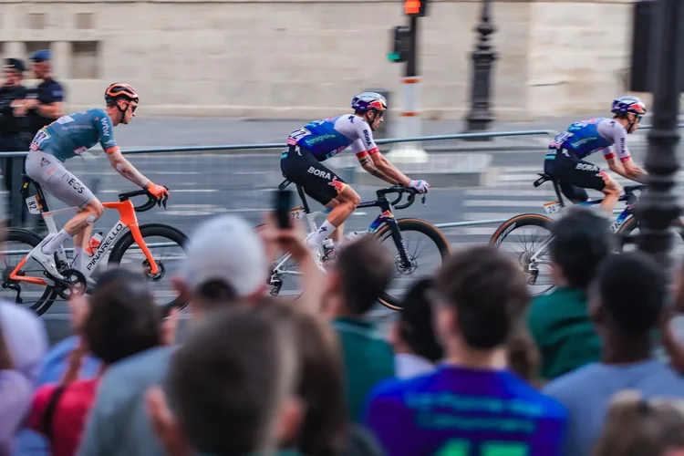 Panning shot of INEOS and Bora riders on the final stage of the Tour de France 2026 in Paris