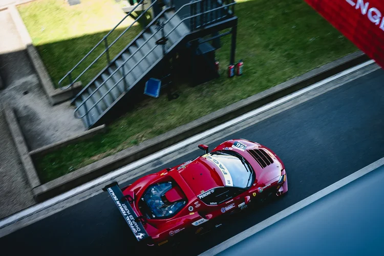 A red race car from above beside the stairs and grass