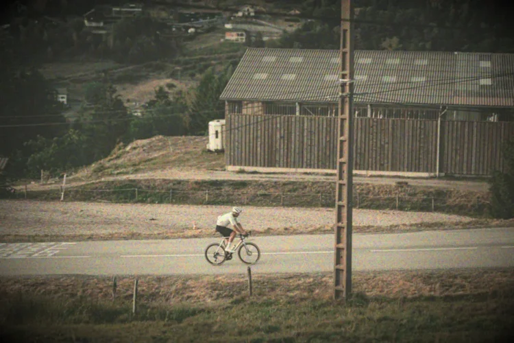 A lone rider passing a timber barn in the hills