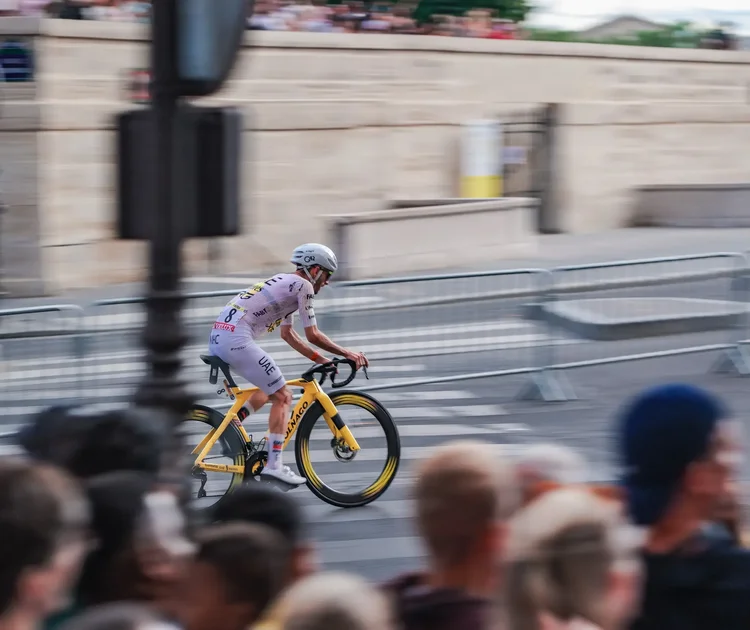 Panning shot of a UAE Team Emirates rider on a yellow Colnago on the final stage of the Tour de France 2026