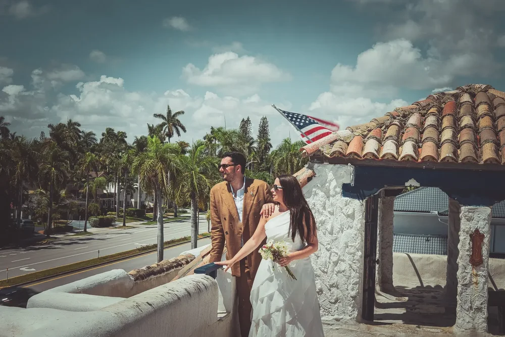 Newlyweds on a Miami rooftop under palm trees