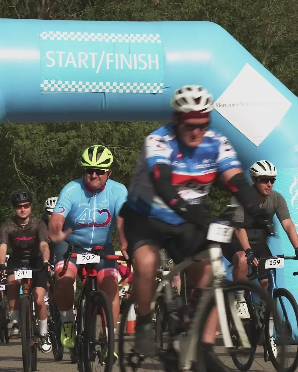 Riders setting off through the start arch of a charity sportive