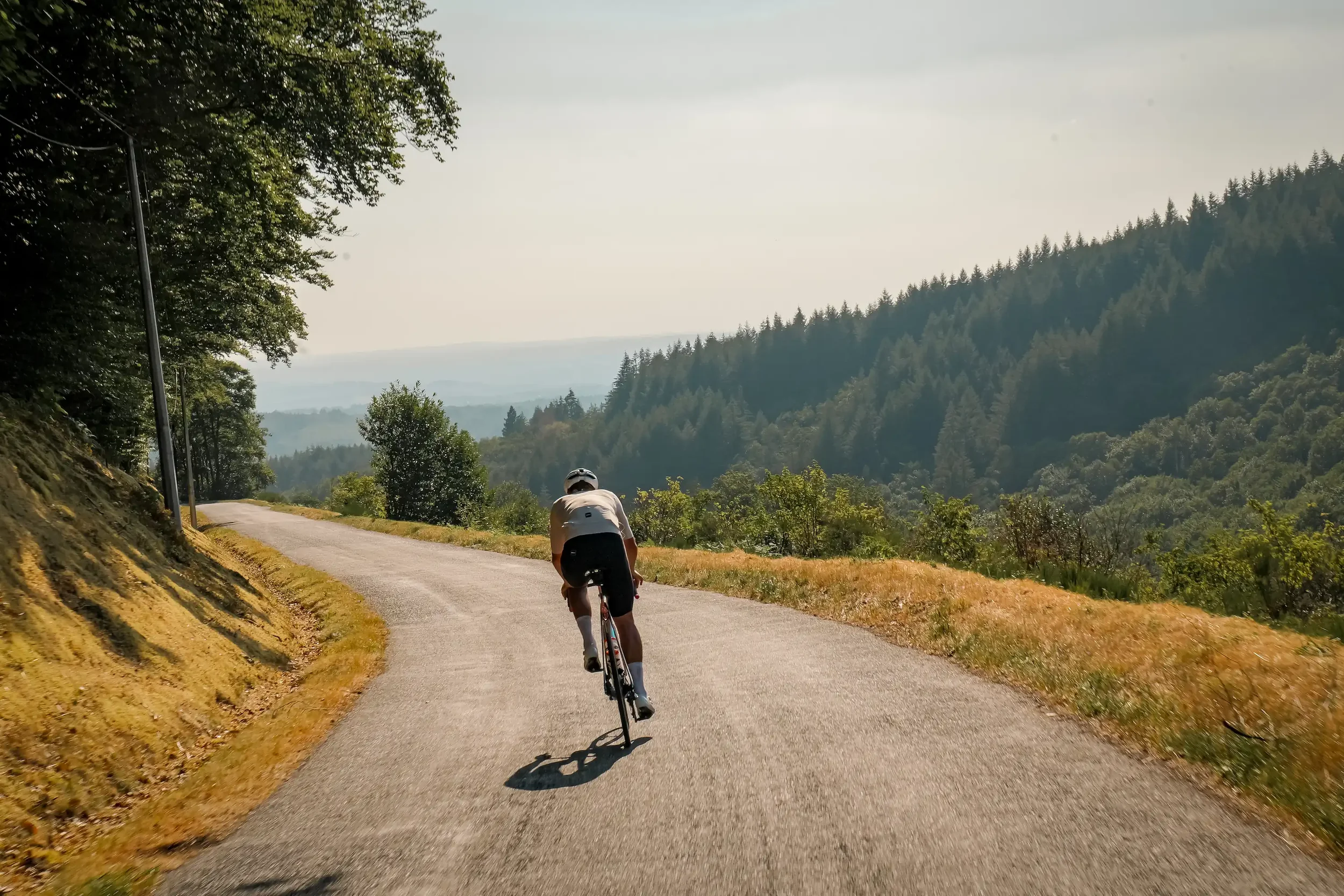 James Golding climbing a forested road on the Tour de France route during 2112, filmed by Fairford Studios