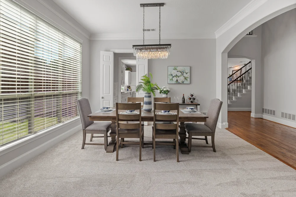 Formal dining room with a crystal chandelier and tall windows