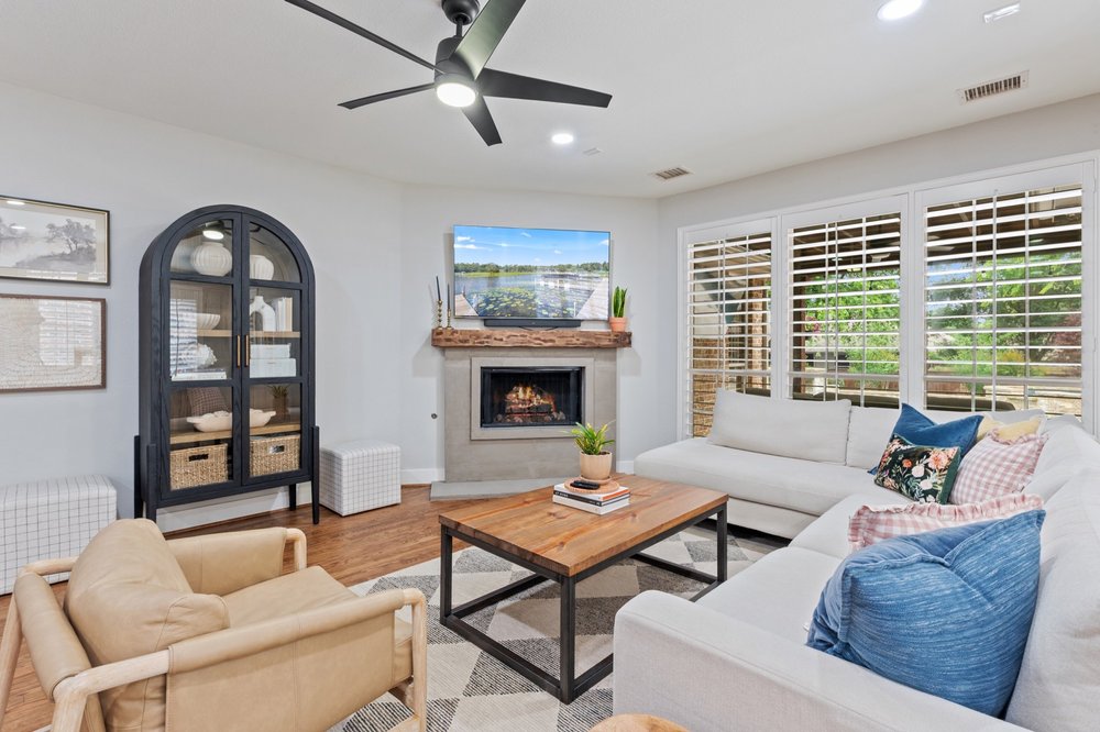 Light-filled living room with fireplace and plantation shutters in McKinney