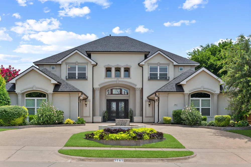Two-story home with a circular driveway and landscaped entrance
