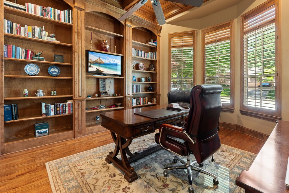 Home office with built-in bookshelves and plantation shutters