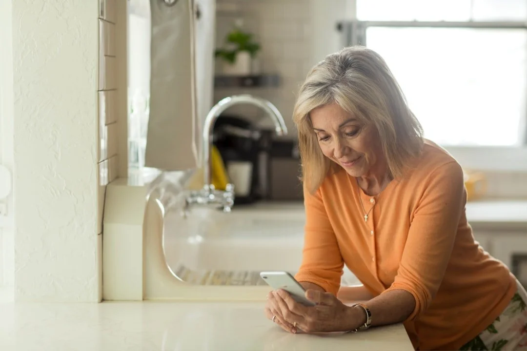 Older adult smiling while using a smartphone
